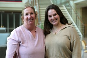 Two women standing next to one another.