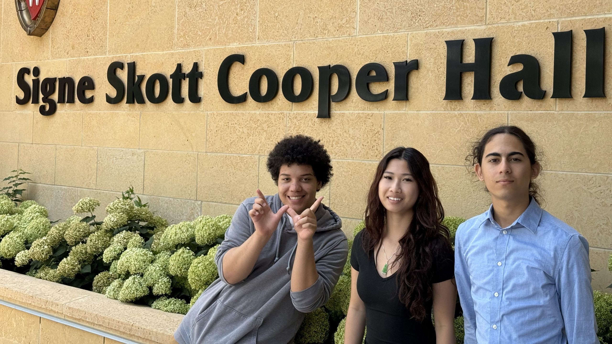 Students in front of building sign.